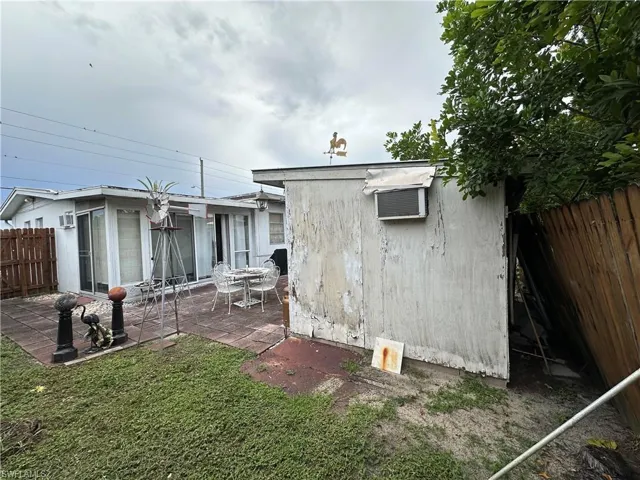 View of side of home featuring a patio and an outdoor structure