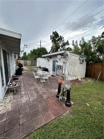 Fenced backyard with a patio, an outbuilding, and outdoor dining space