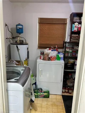 Washroom featuring water heater and separate washer and dryer