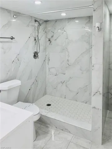 Bathroom with a marble finish shower and vanity