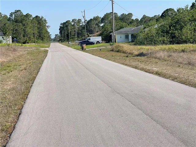 View of asphalt street with view of scattered trees