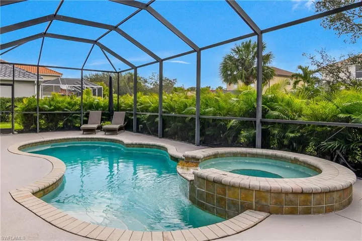 View of pool featuring a pool with connected hot tub, a lanai, and a patio