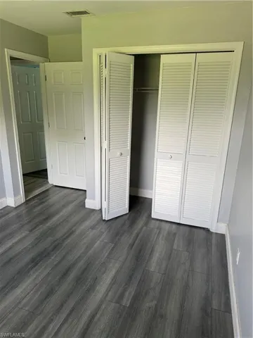 Full bathroom featuring hardwood / wood-style floors, vanity, tiled shower / bath combo, and toilet