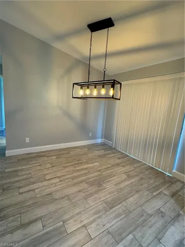Kitchen with white cabinetry, light hardwood / wood-style flooring, stove, and stainless steel refrigerator with ice dispenser