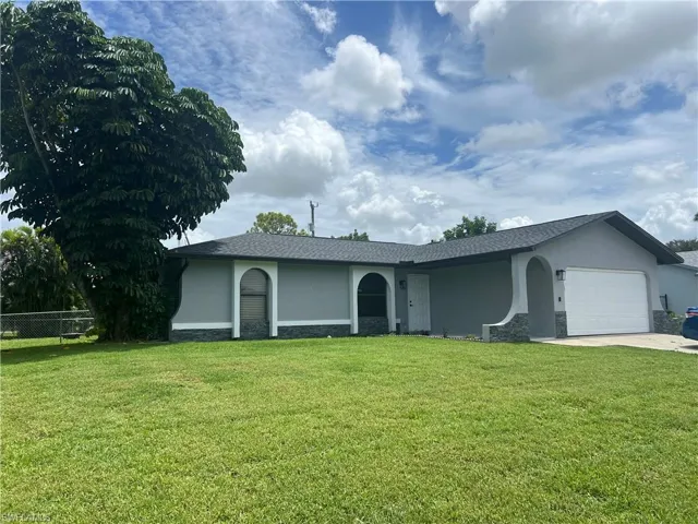 Ranch-style home with a garage and a front yard