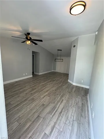 Spare room featuring an inviting chandelier and hardwood / wood-style flooring