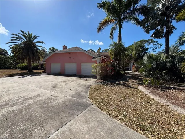 View of home's exterior with a garage, stucco siding, concrete driveway, and a chimney