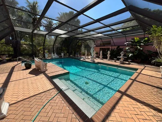 Swimming pool with glass enclosure, a sunroom, and a patio