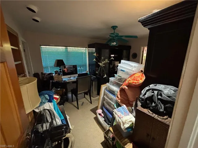 Office area featuring light carpet and a ceiling fan
