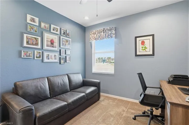 Office space with light colored carpet and a ceiling fan