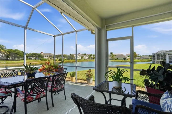 Sunroom / solarium with a water view, outdoor dining area, and a residential view