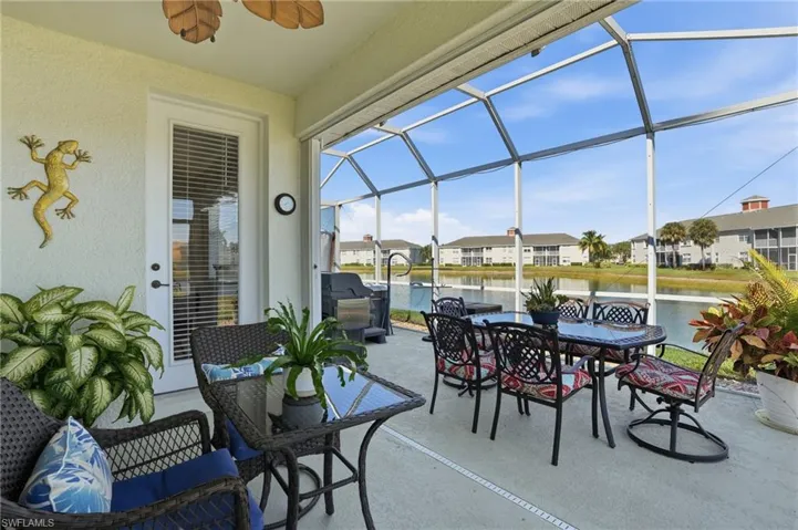 View of patio featuring a sunroom, a lanai, a water view, a ceiling fan, and outdoor dining area