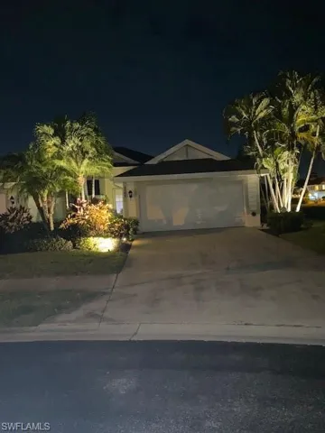 View of front of home with driveway and an attached garage