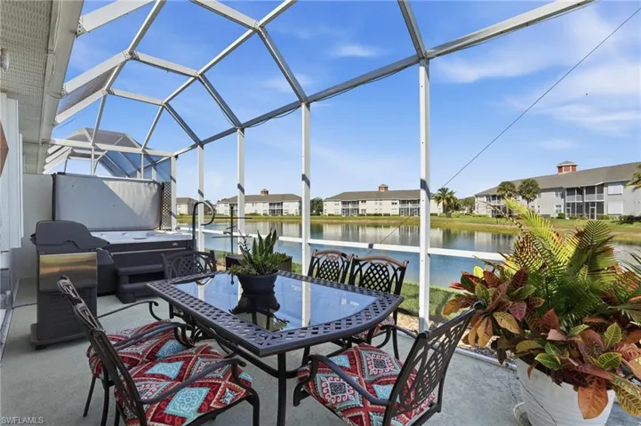 View of patio featuring a lanai, a sunroom, a water view, area for grilling, and a residential view