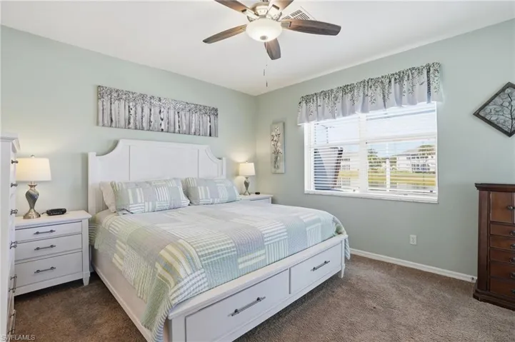 Bedroom with dark carpet and a ceiling fan