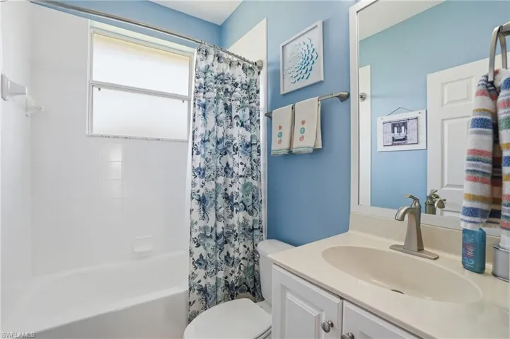 Full bath featuring vanity and shower / bath combo with shower curtain