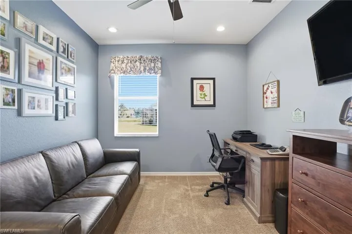 Home office featuring light colored carpet, ceiling fan, and recessed lighting