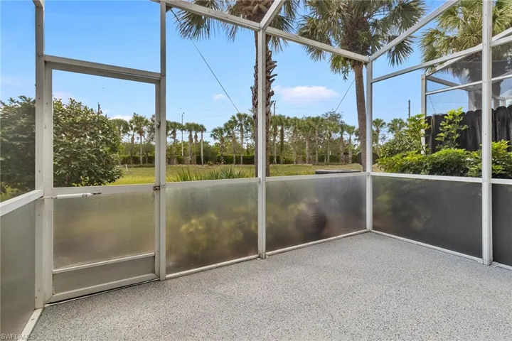 Screened enclosure with a textured gray floor and partial privacy screening