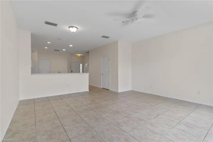 Tile flooring, recessed lighting, ceiling fan, and a half-wall partition