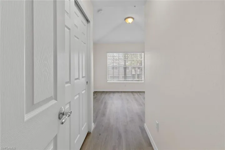 Recessed lighting, wood-finish flooring, paneled interior doors, and a window with blinds