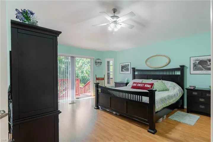 Bedroom featuring access to exterior, light hardwood / wood-style floors, and ceiling fan
