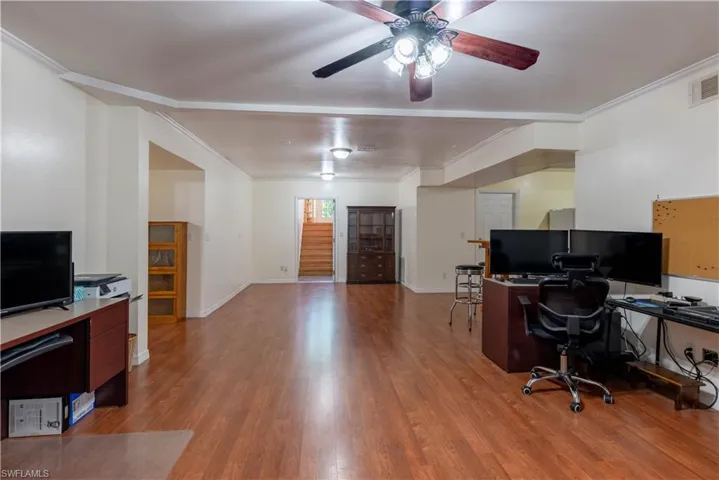 Home office featuring ornamental molding, light hardwood / wood-style floors, and ceiling fan