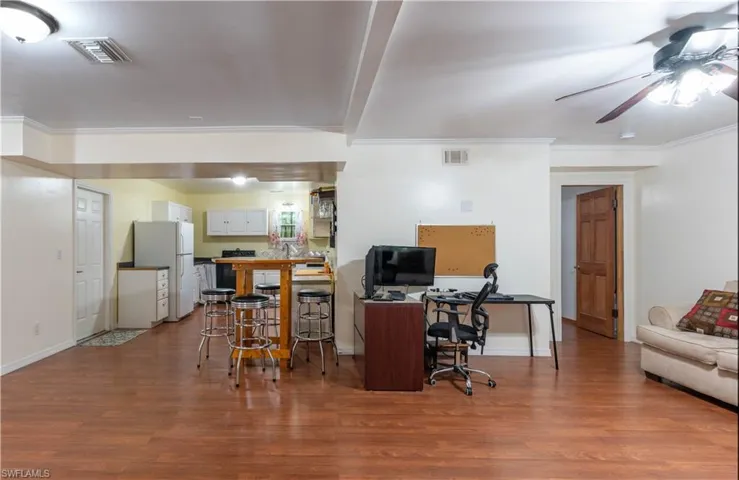 Office with ornamental molding, hardwood / wood-style flooring, and ceiling fan