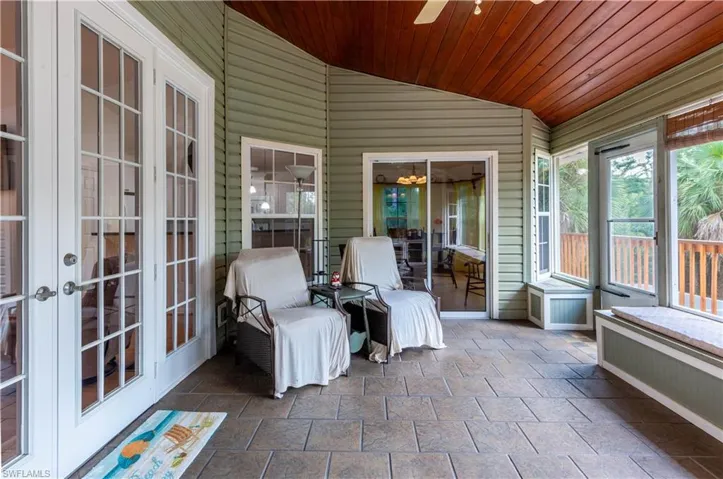Sunroom with lofted ceiling, wooden ceiling, and ceiling fan