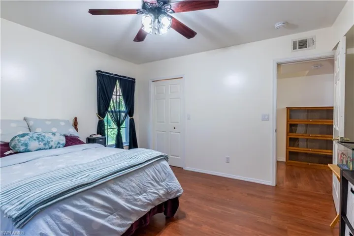 Bedroom featuring wood-type flooring, ceiling fan, and a closet