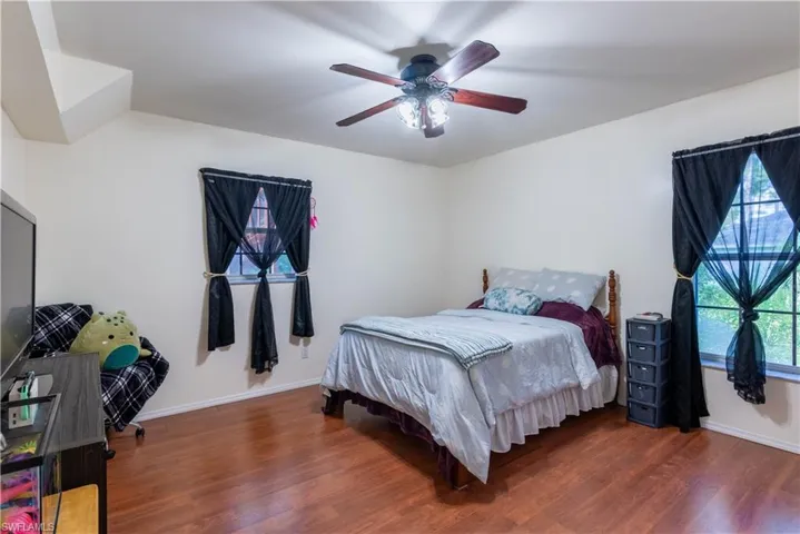 Bedroom with dark wood-type flooring and ceiling fan