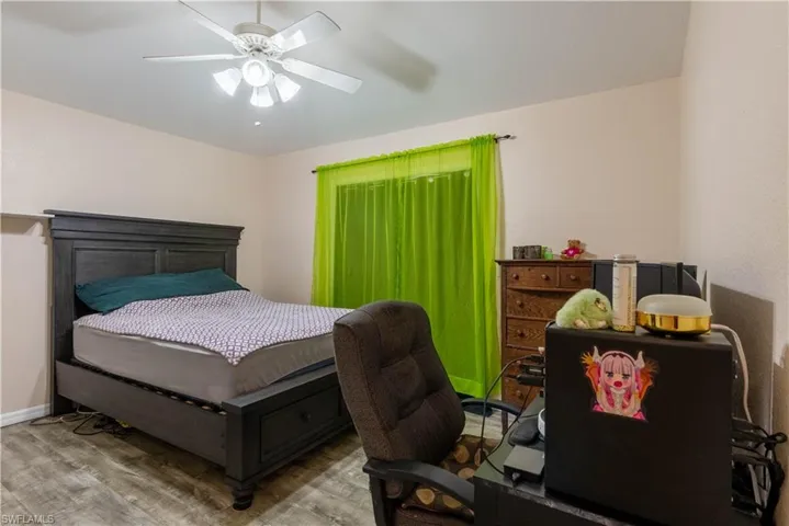 Bedroom with ceiling fan and wood-type flooring