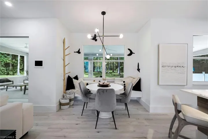 Dining space with a healthy amount of sunlight, light wood-type flooring, and a chandelier