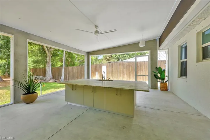 Unfurnished sunroom featuring sink and ceiling fan