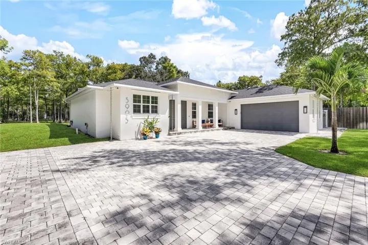 Ranch-style home featuring a garage and a front yard