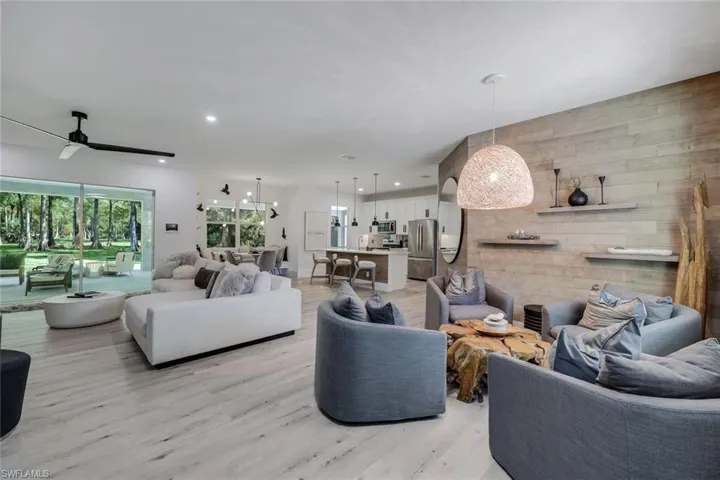 Living room with ceiling fan and light hardwood / wood-style flooring