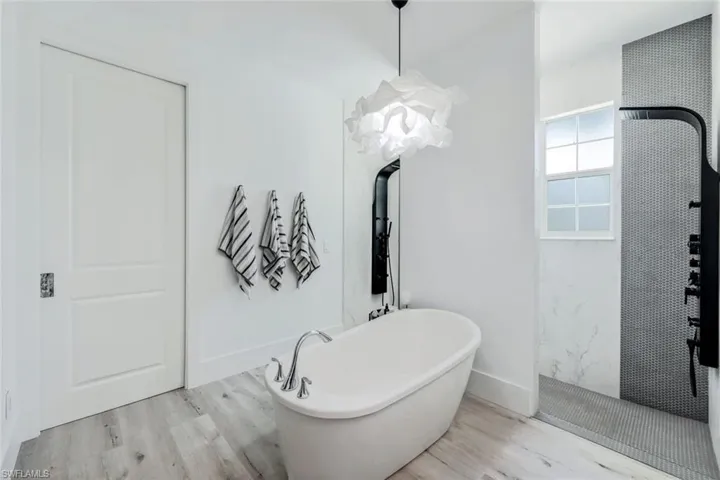 Bathroom with a washtub and hardwood / wood-style flooring