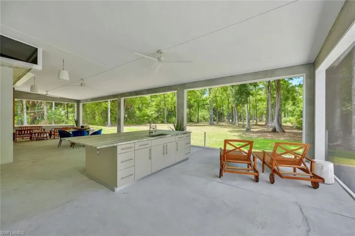Sunroom with ceiling fan and sink