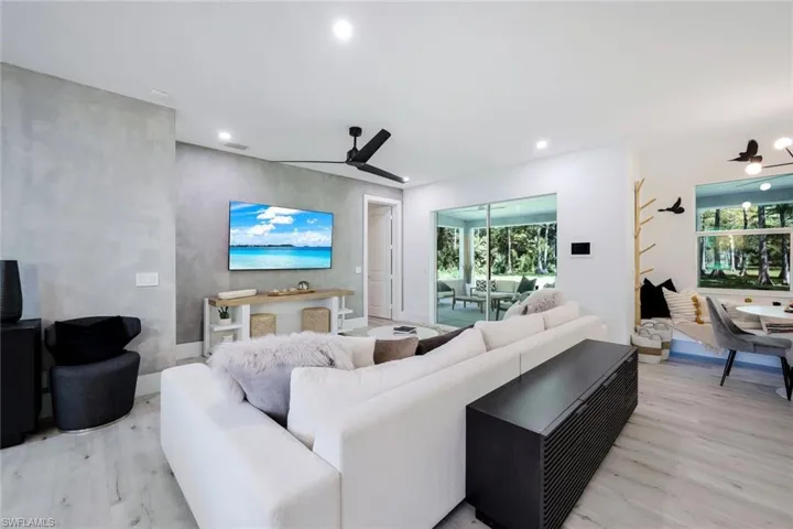 Living room with ceiling fan and light hardwood / wood-style flooring