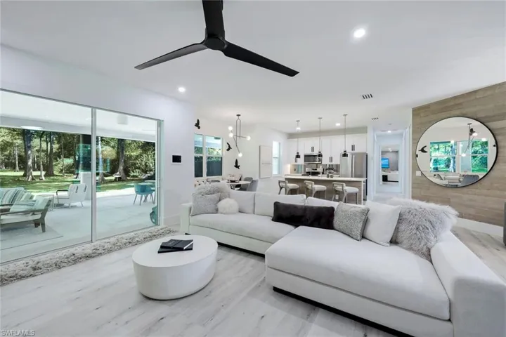 Living room featuring ceiling fan, wood walls, and light hardwood / wood-style flooring