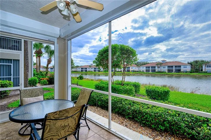 Sunroom / solarium featuring ceiling fan and a water view
