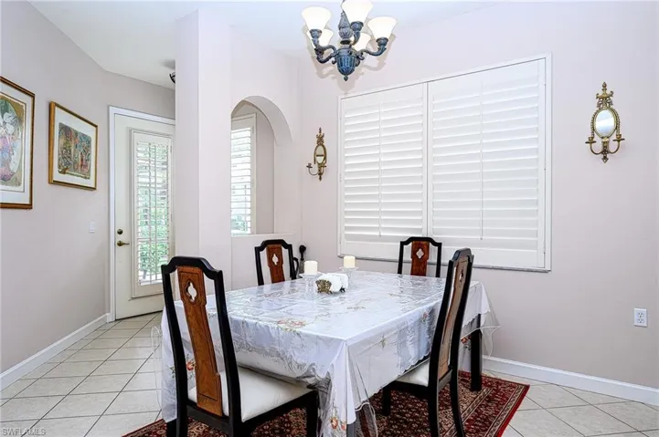 Tiled dining space featuring an inviting chandelier