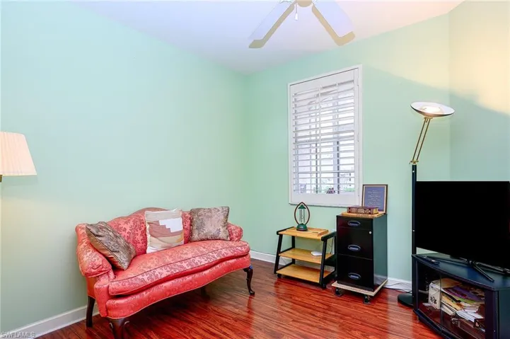 Sitting room with ceiling fan and dark hardwood / wood-style flooring