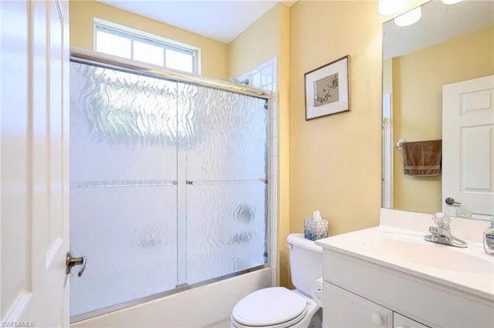 Full bathroom featuring vanity, toilet, and enclosed tub / shower combo