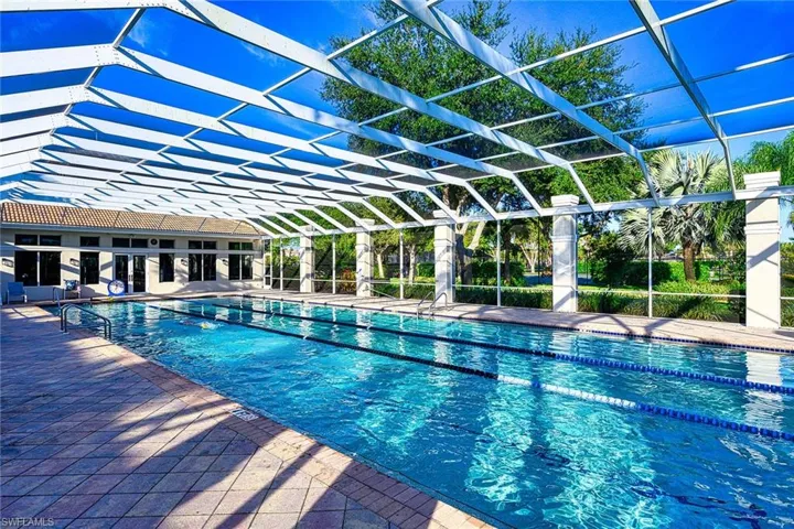 View of pool with a patio and glass enclosure