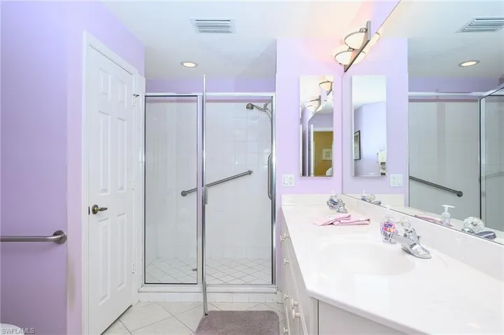 Bathroom with vanity, tile patterned floors, and a shower with shower door