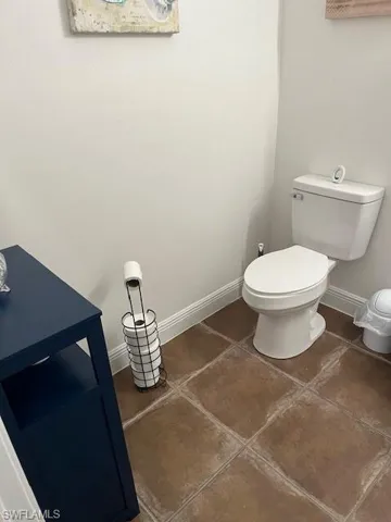 Half bathroom with baseboards and tile patterned floors
