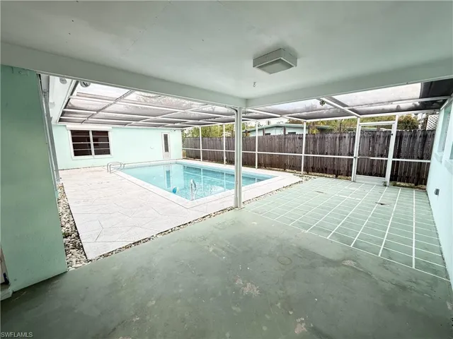 View of pool featuring a lanai, patio surround, and a fenced backyard