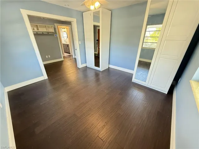 Unfurnished bedroom featuring dark wood finished floors and a ceiling fan