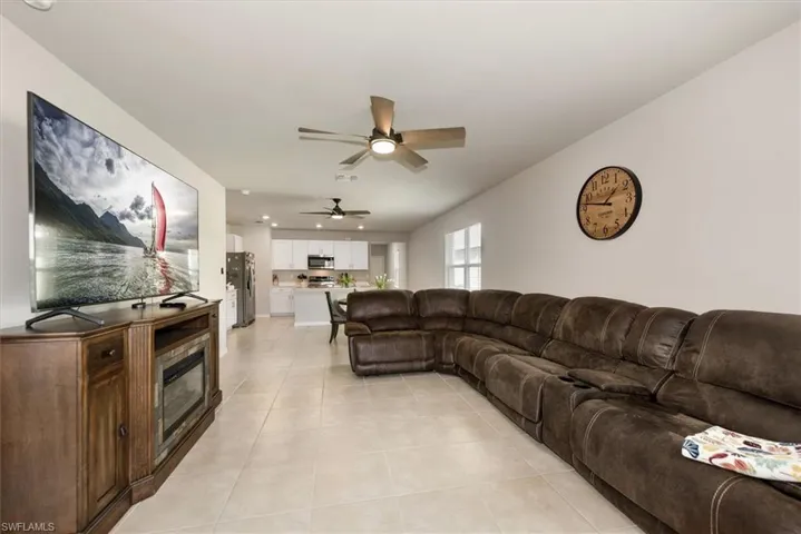 Living area with ceiling fan, light tile patterned floors, and recessed lighting