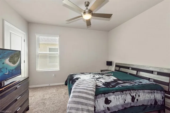 Carpeted bedroom with baseboards and a ceiling fan